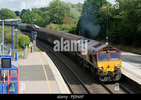 Classe 66 locomotiva diesel tirando un treno merci attraverso la stazione di Hatton, Warwickshire, Regno Unito Foto Stock