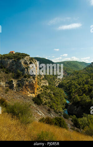 Bella vista dall'alto di un solitario e carino casa in una scogliera di montagna vicino al fiume Jucar in Cuenca. Vista dal Belvedere Ventano del Diablo. Foto Stock