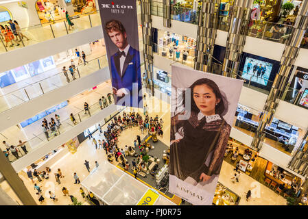 La città di Ho Chi Minh, Vietnam - 29 Aprile 2018: l'interno di Saigon Centre Shopping Mall con la folla e due grandi cartelloni di annunci (Kiton, Kimmay) Foto Stock
