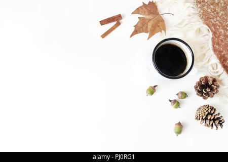 Caduta di stile femminile composizione. Scena di prima colazione con lo smalto mug, caffè, foglie secche, cannella e plaid. Tavolo bianco sullo sfondo. Autunno accogliente ancora in vita. Appartamento laico, vista dall'alto. Foto Stock