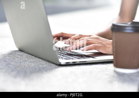 Giovane imprenditrice seduta al lavoro di strada con il computer portatile, close-up foto. Business, istruzione, concetto di stile di vita. Foto Stock