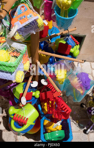 Vista ritagliata della visualizzazione di plastica colorati giocattoli da spiaggia per la vendita al di fuori del negozio di souvenir in Menorca, Spagna Foto Stock