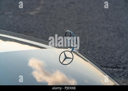 Mercedes mascotte del cofano con nuvole riflettono sul cofano Foto Stock