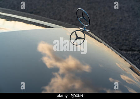 Mercedes mascotte del cofano con nuvole riflettono sul cofano Foto Stock