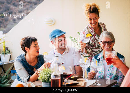 Gruppo di adulti di età mista da 40 a 80 per celebrare insieme a casa nella terrazza con cibo e vino. amicizia insieme persone concetto avente un divertente Foto Stock