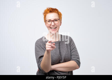 Felice moda giovane donna in posa per la telecamera mentre rivolti a voi. Foto Stock
