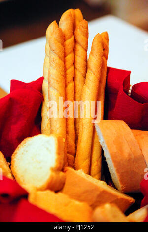 Croccante di stile Italiano grissini lungo con baguette affettata nel cestino del pane sul tavolo nel ristorante a Udine, Italia Foto Stock