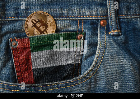 Golden BITCOIN (BTC) cryptocurrency nella tasca dei jeans con la Bandiera degli Emirati Arabi Uniti in Jeans Denim Texture. Foto Stock