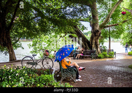 Diverse coppie sotto l'ombra godendo di una vista sul lago. Foto Stock