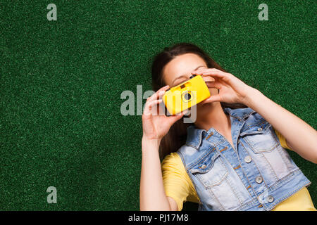 Donna sdraiati sull'erba e fotografando Foto Stock