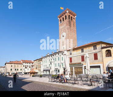 Medievale Torre Civica, Piazza Garibaldi, Bassano del Grappa, Vicenza, Italia con persone in attesa per la prima colazione a tavoli all aperto in Early Morning Light Foto Stock