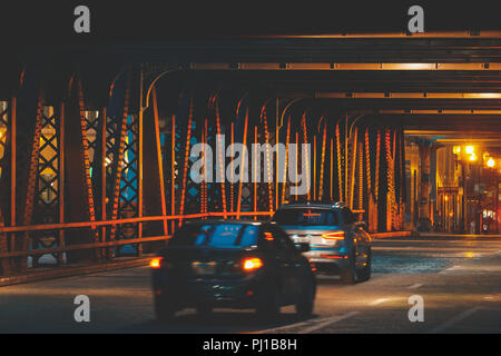 Cars driving sotto elevata binari del treno e il ponte sul fiume Chicago di notte, Illinois, Stati Uniti Foto Stock