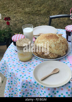 Pila di frittelle con marmellata su un tavolo per la colazione Foto Stock