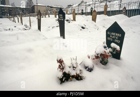 4 Marzo 1993 durante l'assedio di Sarajevo: fiori, soffocato con neve, contrassegnare la tomba di un diciassette anno-vecchio ragazzo in un angolo del cimitero di Lion, appena al di sotto dell'Ospedale Kosevo. Foto Stock