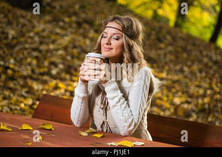 Bella ragazza boho gode di bere il caffè nel parco. Foto Stock