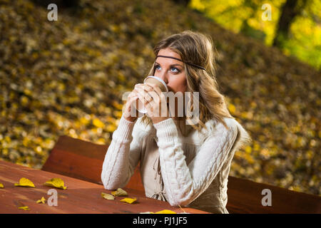 Bella ragazza boho gode di bere il caffè nel parco. Foto Stock