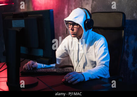 Giovane maschio video gioco addict nel cofano la riproduzione di tiratori nella notte Foto Stock
