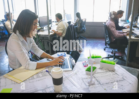 Executive femmina utilizzando laptop alla scrivania Foto Stock