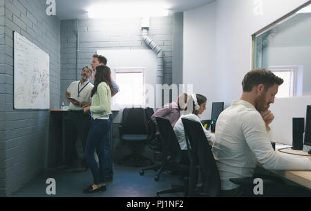 La gente di affari discutendo su whiteboard Foto Stock