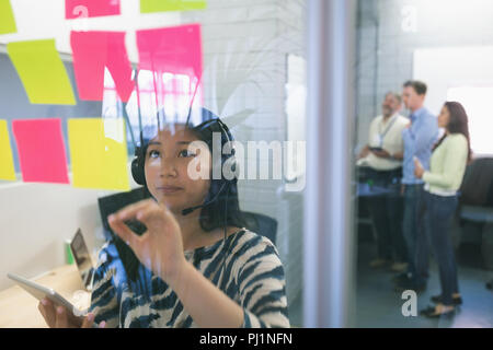 Executive femmina guardando sticky notes Foto Stock