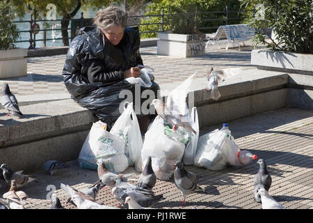 Bag-lady alimentare piccioni, Paseo Alcalde Marqués de Contadero, Sevilla, Andalusia, Spagna Foto Stock