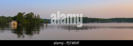 Un piccolo cottage sul lago su un isola nel Muskokas, Ontario, a sunrise. Foto Stock