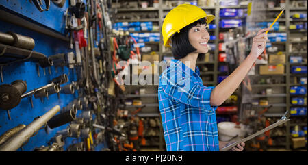 Immagine composita delle donne architetto azienda appunti e gesticolando contro uno sfondo grigio Foto Stock