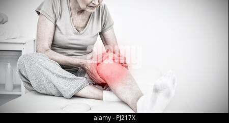 Immagine composita di senior donna con le sue mani su di un ginocchio doloroso Foto Stock