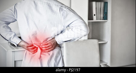 Immagine composita di casual uomo d affari toccando il suo mal di schiena Foto Stock