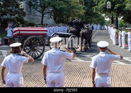 Aspiranti guardiamarina salutate come bandiera drappeggiati scrigno di John McCain come a cavallo il cassettone processi per l'Accademia Navale degli Stati Uniti cimitero per il suo servizio di sepoltura il 2 settembre 2018 in Annapolis, Maryland. John S. McCain, III si è laureato dall'Accademia Navale degli Stati Uniti in 1958. Egli è stato un pilota della marina degli Stati Uniti, un prigioniero di guerra nel Vietnam, i membri del Congresso degli Stati Uniti e il senatore e due volte candidato presidenziale. Ha ricevuto numerosi premi, tra cui la stella d'argento, legione di merito, cuore viola e Distinguished Flying Cross. Foto Stock