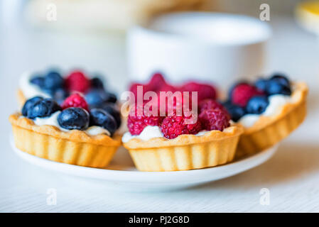 Torte dolci con frutti di bosco su una piastra Foto Stock