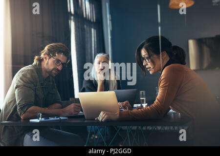 Business donna condividendo le sue idee con il computer portatile per i colleghi. La gente di affari riunione in ufficio e discutere su Nuovo progetto. Foto Stock