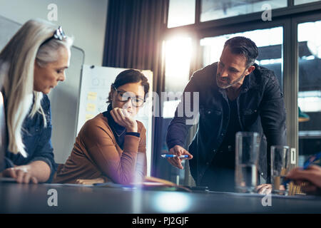 Team Aziende in seduta office board camera e avente una riunione di brainstorming. La gente di affari seduti insieme e discutere di un nuovo piano. Foto Stock