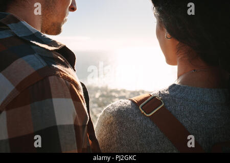 Vista posteriore in prossimità della coppia di viaggiatori in piedi all'aperto e guardando paesaggi marini. Giovane uomo e donna che guarda la vista Foto Stock