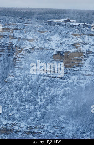 Vista invernale della storica El Tovar Hotel appollaiate sul bordo della coperta di neve South Rim al Parco Nazionale del Grand Canyon in Arizona. Foto Stock