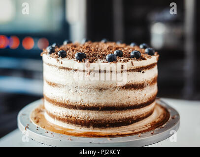 Close up di torta al cioccolato con crema di formaggio e bacche. Foto Stock