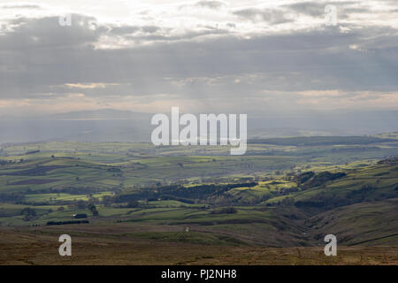 Paesaggio pennini, Eden Valley, e distante Lake District colline prese da Hartside Top vicino a Alston nel Pennines con i raggi del sole attraverso la rottura Foto Stock