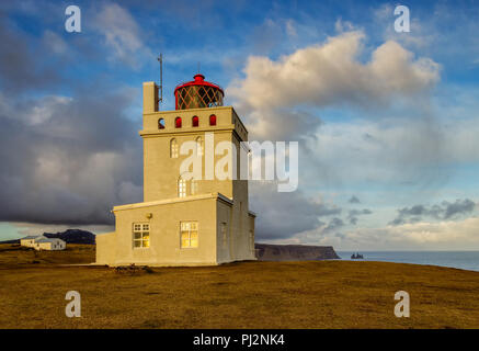 Il faro di Dyrholaey si erge solitaria sopra le scogliere sulla costa sud dell'Islanda e le protezioni sul mare. Foto Stock