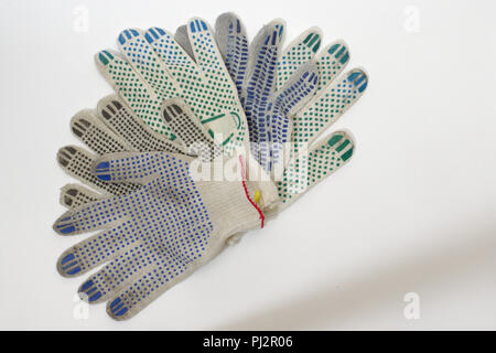 Pila di guanti di cotone con gomma multicolore punti, polsini elastici,  bordati da blu, rosso e giallo orli. Lavorando abbigliamento protettivo,  lavorati a maglia Foto stock - Alamy