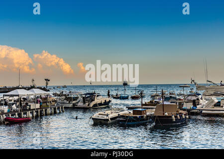 AMALFI (SA). Italia - Agosto 30, 2018: i turisti sono rilassanti su barche ormeggiate nel porto di Amalfi al tramonto Foto Stock