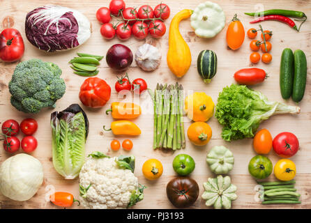 Assortimento di coloratissimi fresche verdure organiche su legno tabella di pino, cucina creativa sfondo, griglia, vista dall'alto, il fuoco selettivo Foto Stock