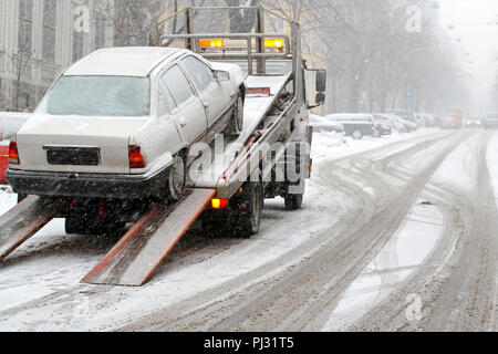 Auto rompersi e il traino a neve street Foto Stock