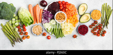 Mangiare sano concetto, al di sopra di vista di rainbow buddha bowl, vari ortaggi, la carota e la zucchina, cavolo, ceci, cetrioli e pomodori, su legno Foto Stock