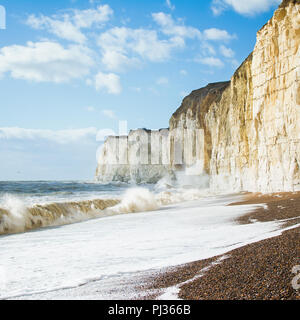 Chalk scogliere tra Seaford e Newhaven, vicino Tide Mills, East Sussex, Enlgand in una giornata di vento in una alta marea, quadrato, il fuoco selettivo Foto Stock