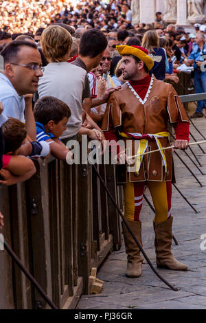 Un uomo dal Valdimontone (RAM) Contrada attende per l'assegnazione dei cavalli cerimonia per iniziare in Piazza del Campo Palio di Siena, Italia Foto Stock