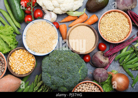 Varietà ofrains in ciotole e verdure broccoli, squash, fagioli, pomodori, carote, avocado, quinoa, piselli, riso, avena, il fuoco selettivo Foto Stock
