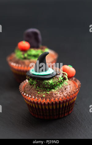 Halloween Holiday cibo colorato brownie fantasia tortina con strega e zucca decorare fondente Foto Stock