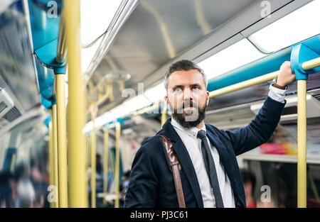 Hipster imprenditore dentro la metropolitana nella città, in viaggio per lavoro. Foto Stock