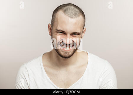 Close-up verticale di un divertente uomo barbuto rendendo crazy face Foto Stock