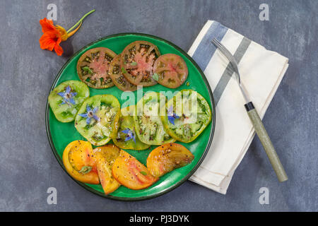 Antica pomodori. Insalata di vari e variopinta antico pomodori sfondo ardesia Foto Stock